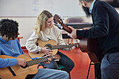 Teenagers attending guitar lesson