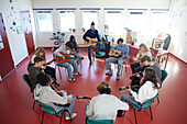 Teenagers attending guitar lesson