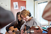 Teenagers attending guitar lesson