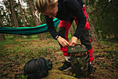 Female hiker packing backpack in forest