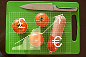 Finanzkarte und Tomaten mit Wurst auf Schneidebrett