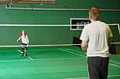 Mädchen und Mann spielen Badminton