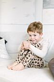 Smiling boy sitting on sofa