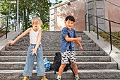 Children dancing on stairs in summer