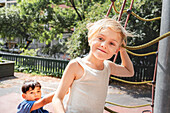 Child friends climbing net in park