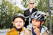 Mutter fährt Fahrrad mit Kindern in der Kutsche