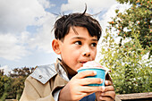 Junge isst Eis aus einem Becher