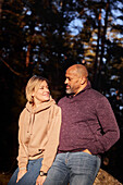 Couple resting in forest at sunny day