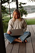 Woman using laptop on porch
