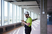 Arbeiter benutzt Handy auf der Baustelle