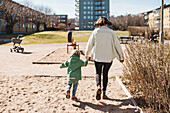 Rückansicht von Mutter und Kind beim gemeinsamen Spaziergang