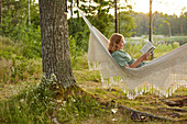 Woman reading book on hammock