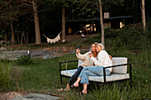 Female friends taking selfie on bench