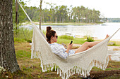 Woman using phone on hammock