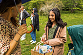 Menschen im Regen stehend mit Regenschirm und Blumenkorb