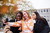 Drei junge Studentinnen machen ein Selfie auf dem Campus