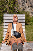 Reife Frau entspannt auf Sonnenliege