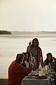 Family having meal at lake