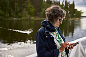 Frau telefoniert mit Handy am See