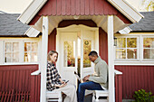 Couple sitting in front of wooden house