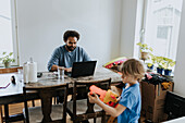 Man working from home and taking care of child