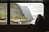 Young woman photographing fiord