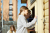 Girls looking through wooden building window