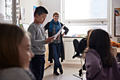 Boy reading in front of class