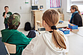 Rückansicht eines Mädchens, das im Klassenzimmer sitzt