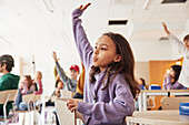 Girl with raised hand in classroom
