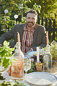 Smiling man at table in garden