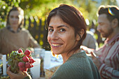 Lächelnde Frau am Tisch im Garten