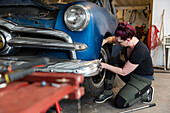 Woman repairing vintage car