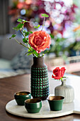 Blumen in Vasen und grünen Tassen