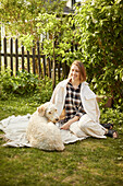 Woman relaxing with dog in garden