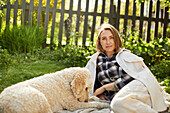 Woman relaxing with dog in garden