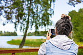 Senior woman photographing nature with smart phone