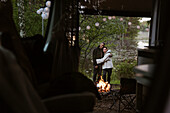 Couple hugging by campfire
