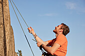 Male rock climber belaying