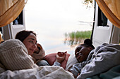 Women lying in bed in camper van