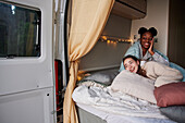 Women cuddling in bed in camper van