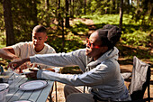 Freunde essen Mahlzeit auf dem Campingplatz