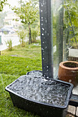 Eimer sammelt Regenwasser im Garten