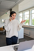 Woman using phone in office