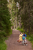 Weibliches Paar beim Spaziergang im Wald mit Fahrrad