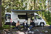 Friends relaxing in front of camper van