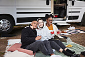 Friends sitting in front of camper van