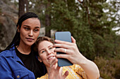 Weibliches Paar macht Selfie im Freien