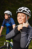Portrait of woman putting on bike helmet