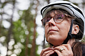 Woman putting on bike helmet